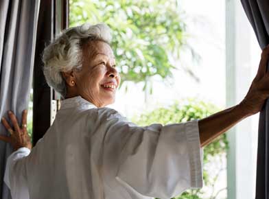 カーテンを開ける老婆